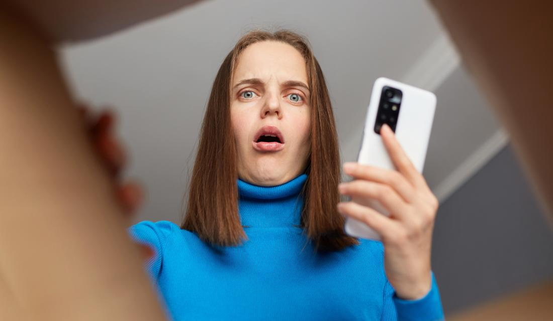 Eine junge Frau schaut erstaunt in einen geöffneten Karton, den sie zugeschickt bekommen hat