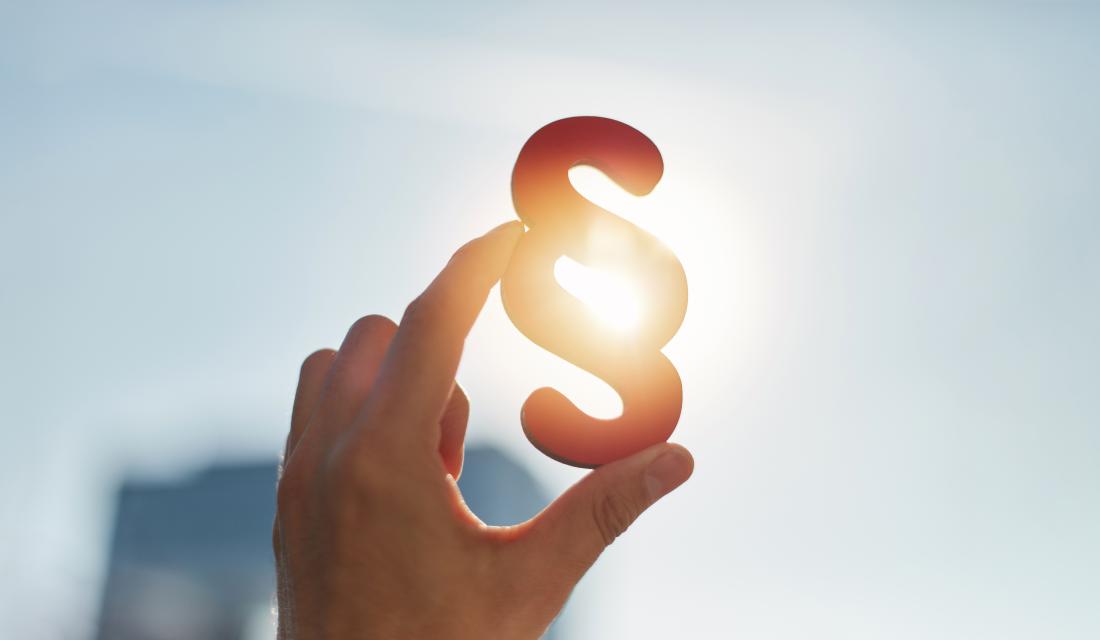 Hand hält Parapraphensymbol gegen die Sonne