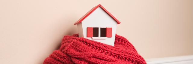 Heizung mit Schal und Miniaturhaus