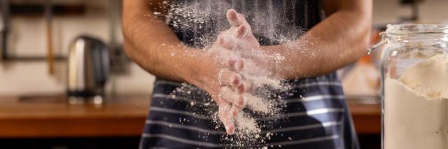 Mann verteilt Mehl auf Arbeitsfläche