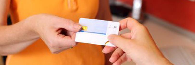 Patientin überreicht ihre Versichertenkarte von der Krankenkasse der Zahnarzthelferin in der Praxis.