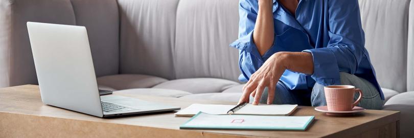 Seniorin sitzt vor Laptop für ihre Videoberatung