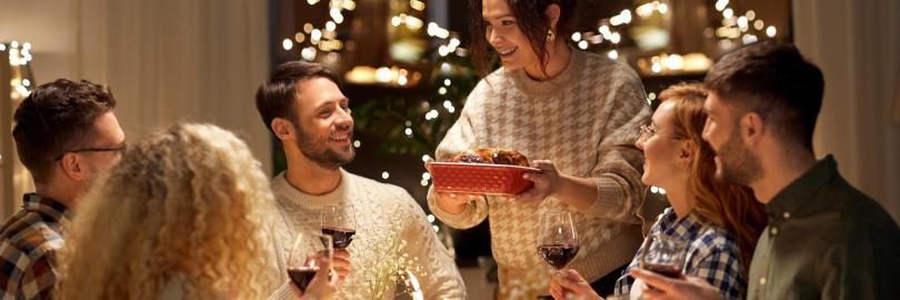 Freunde sitzen gemeinsam am Tisch und genießen ihr Weihnachtsessen