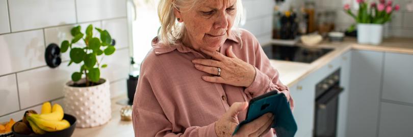 Frau schaut besorgt auf ihr Smartphone
