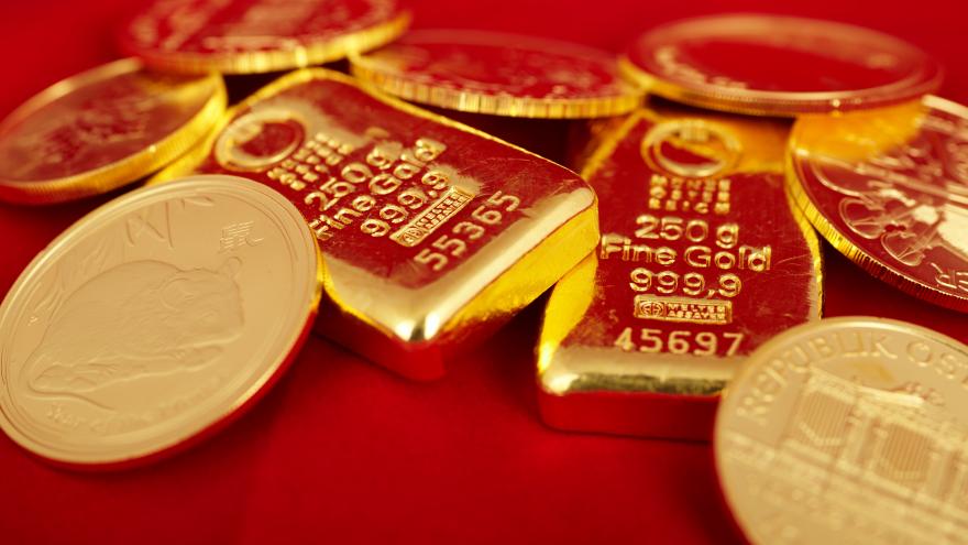 Goldmünzen und Goldbarren auf rotem Samtstoff