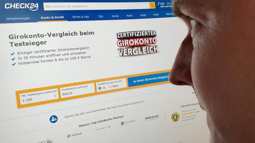 Mann blickt auf PC-Monitor mit der Website check24