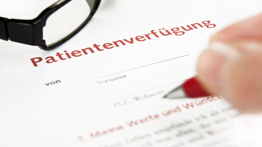 Eine Hand mit Stift zeigt auf ein Dokument, auf dem Patientenverfügung steht.