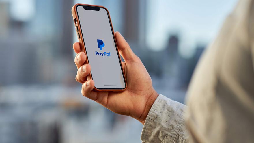 Hand hält Smartphone mit dem Logo von PayPal