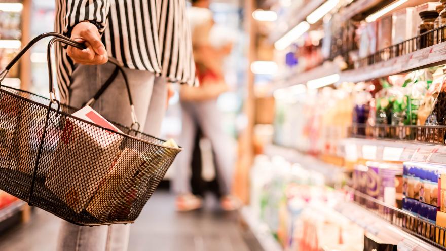 Frau hält einen Korb im Supermarkt 