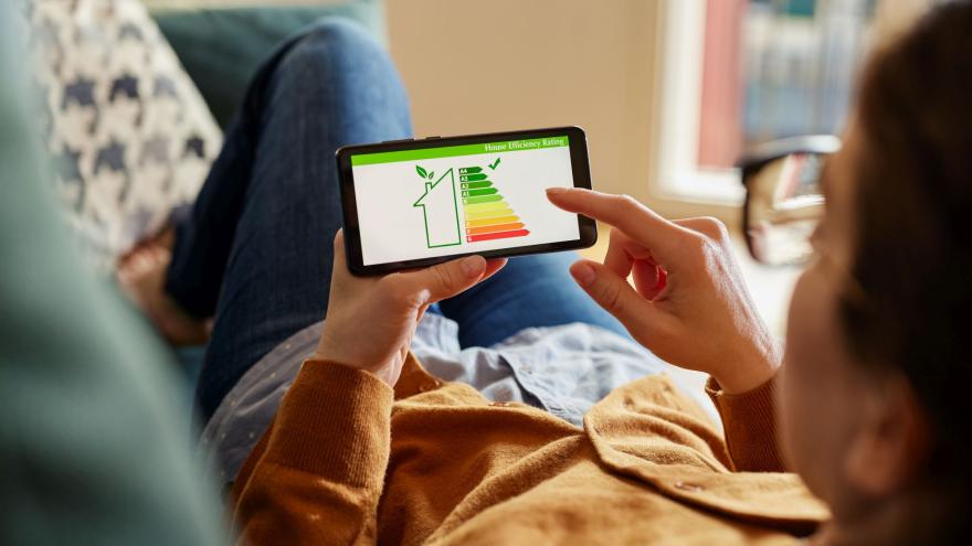 Frau checkt Energieeffizienz auf ihrem Handy