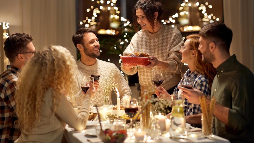 Freunde sitzen gemeinsam am Tisch und genießen ihr Weihnachtsessen