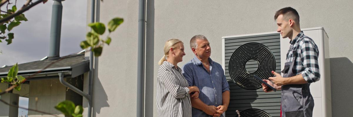 Techniker installiert eine Wärmepumpe am Haus