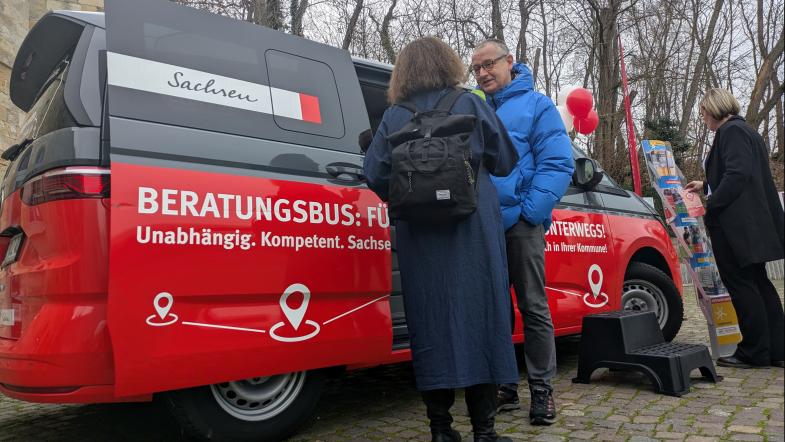 Ralph Kluttig mit Journalistin vor Beratungsbus