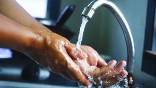 Jemand wäscht sich die Hände in einer Küche