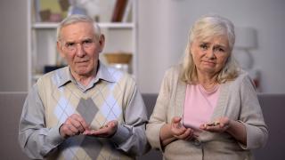 Älteres Ehepaar halten Münzgeld in der Hand und gucken skeptisch