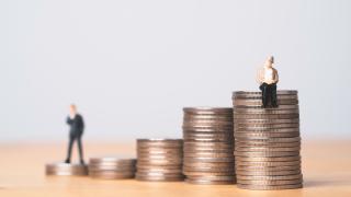 Zwei Figuren sitzen auf einem Gelsstapel aus Münzen