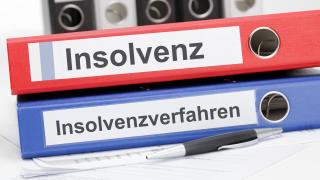 Zwei übereinander liegende Aktenordner, einer mit der Aufschrift Insolvenz, einer mit Insolvenzverfahren