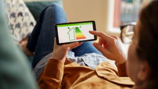 Frau checkt Energieeffizienz auf ihrem Handy
