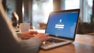 Benutzer, der sich auf einem Laptop-Bildschirm in einen Passwort-Manager einloggt.